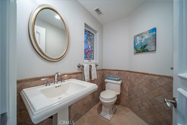 bathroom featuring sink, tile walls, tile patterned floors, and toilet