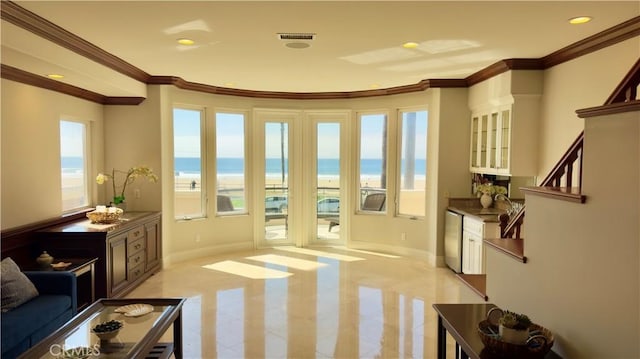 doorway featuring a water view, a healthy amount of sunlight, light tile patterned flooring, and crown molding