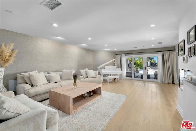 living room featuring french doors and light wood-type flooring