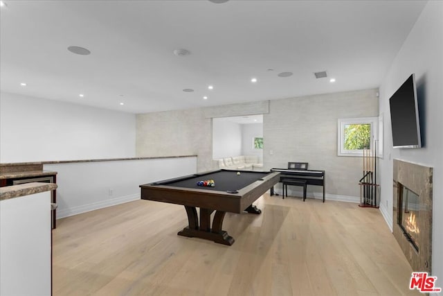 recreation room with pool table, light hardwood / wood-style flooring, and a tiled fireplace