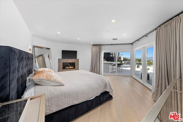 bedroom featuring access to exterior and light wood-type flooring