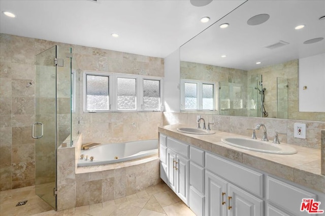 bathroom featuring vanity, tile walls, and shower with separate bathtub