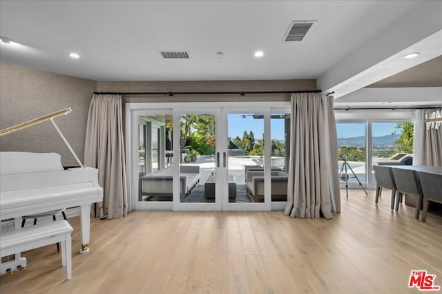 entryway featuring a wealth of natural light, french doors, and light wood-type flooring