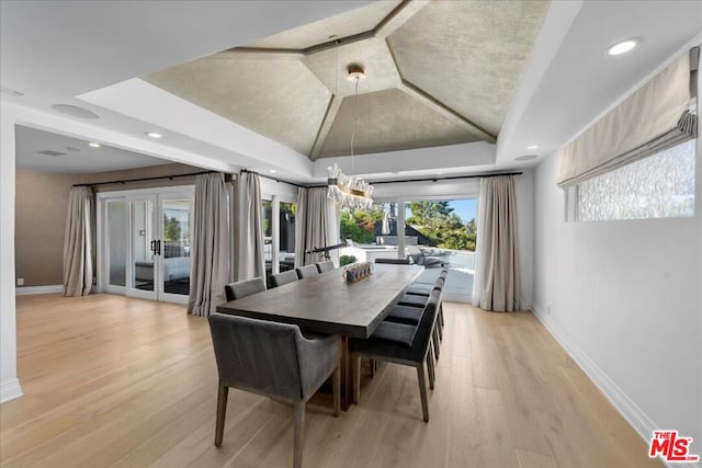 dining space with light hardwood / wood-style floors, lofted ceiling, and french doors