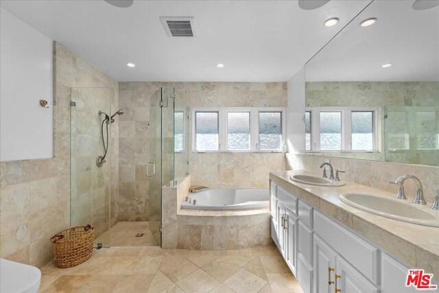 bathroom with vanity and shower with separate bathtub