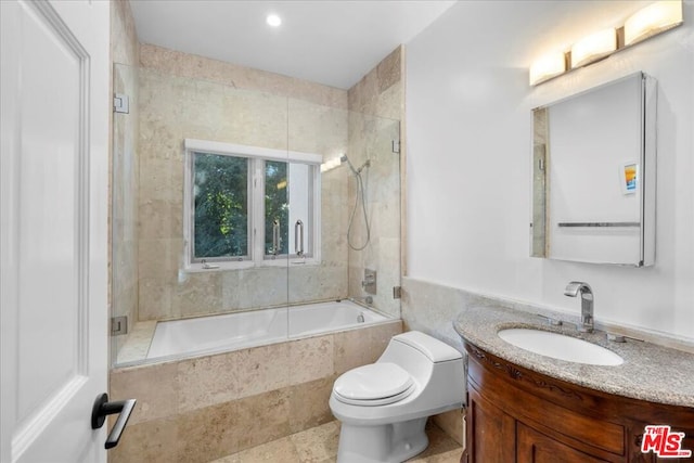 full bathroom with tiled shower / bath, vanity, and toilet