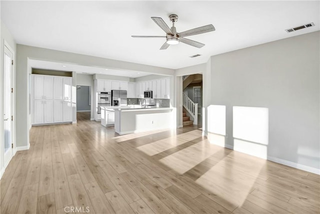 kitchen featuring ceiling fan, light hardwood / wood-style flooring, white cabinets, and appliances with stainless steel finishes