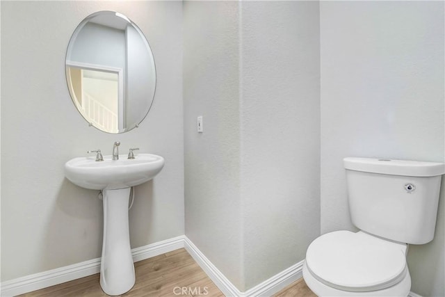 bathroom featuring hardwood / wood-style flooring and toilet