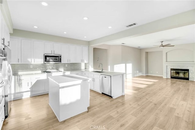 kitchen with a kitchen island, sink, stainless steel appliances, and light hardwood / wood-style flooring