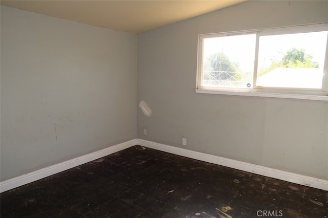 empty room featuring vaulted ceiling