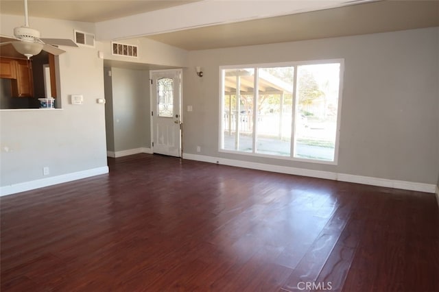 unfurnished living room featuring ceiling fan and dark wood-type flooring