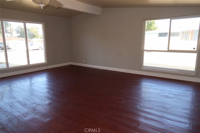 unfurnished room featuring ceiling fan, lofted ceiling with beams, plenty of natural light, and dark wood-type flooring