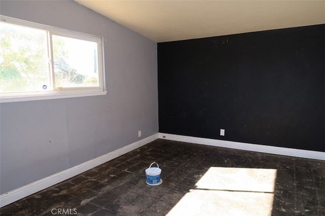 unfurnished room featuring lofted ceiling