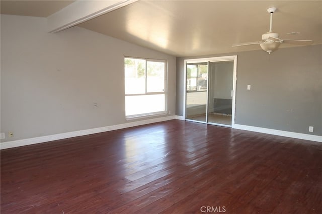 spare room featuring dark wood-type flooring, vaulted ceiling, and ceiling fan