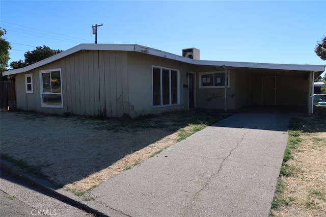 ranch-style home with cooling unit and a carport