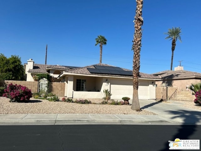 single story home featuring a garage and solar panels