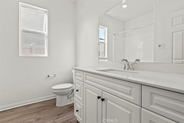 bathroom with a shower, wood-type flooring, toilet, and vanity