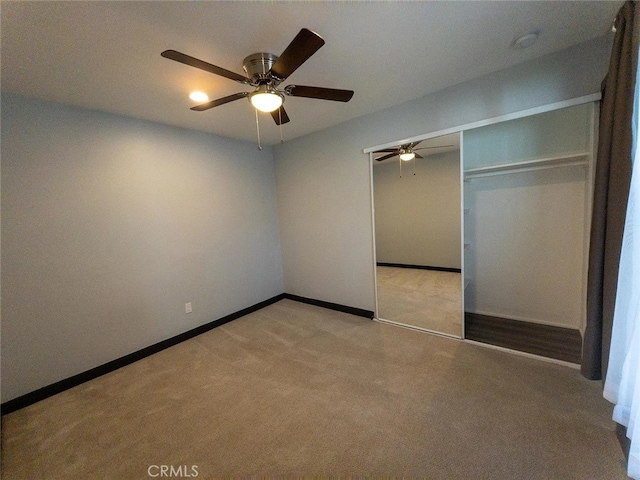 unfurnished bedroom featuring ceiling fan, light colored carpet, and a closet