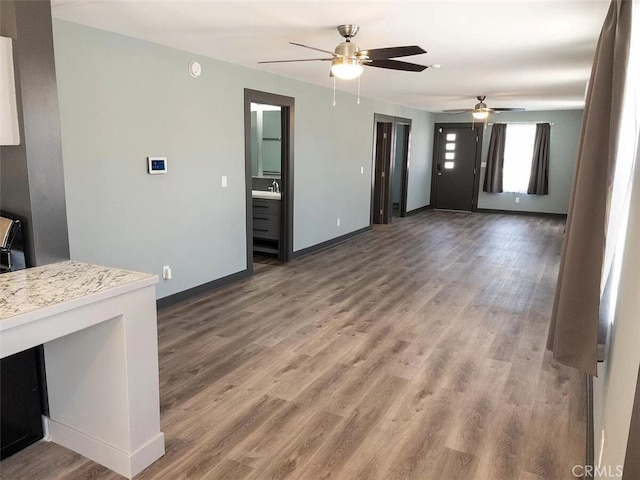 unfurnished living room with dark hardwood / wood-style floors and ceiling fan