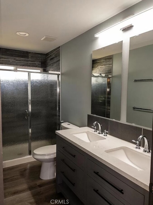 bathroom featuring hardwood / wood-style floors, vanity, walk in shower, and toilet