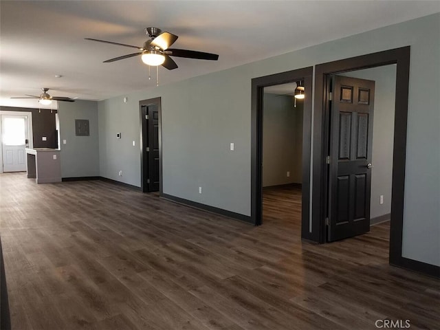 unfurnished living room featuring ceiling fan and dark hardwood / wood-style floors