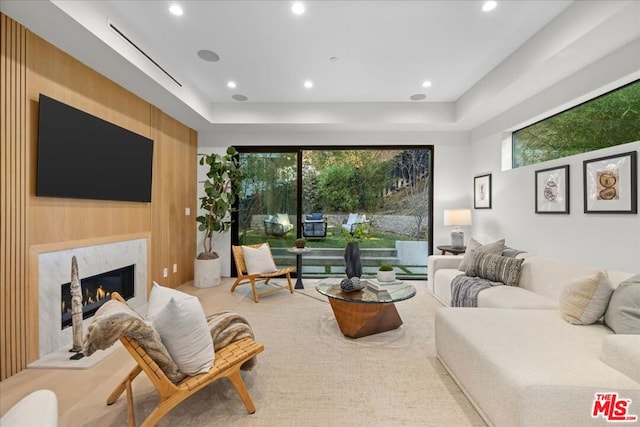 living room featuring a premium fireplace and wood walls