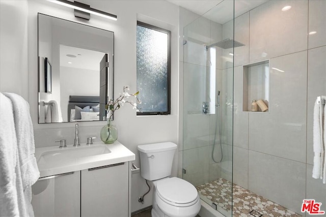 bathroom featuring vanity, toilet, and a shower with shower door