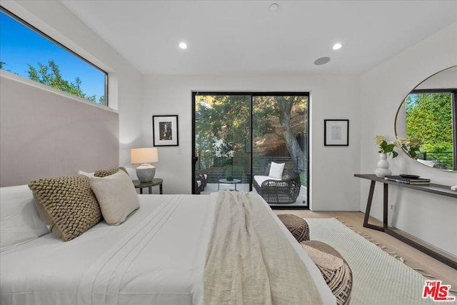 bedroom with multiple windows, access to outside, and light hardwood / wood-style flooring