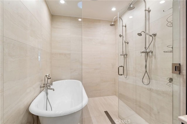 bathroom featuring tile walls and plus walk in shower