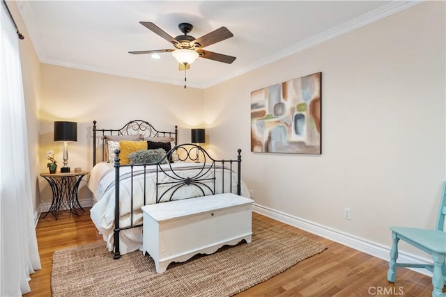 bedroom with ceiling fan, ornamental molding, and hardwood / wood-style flooring