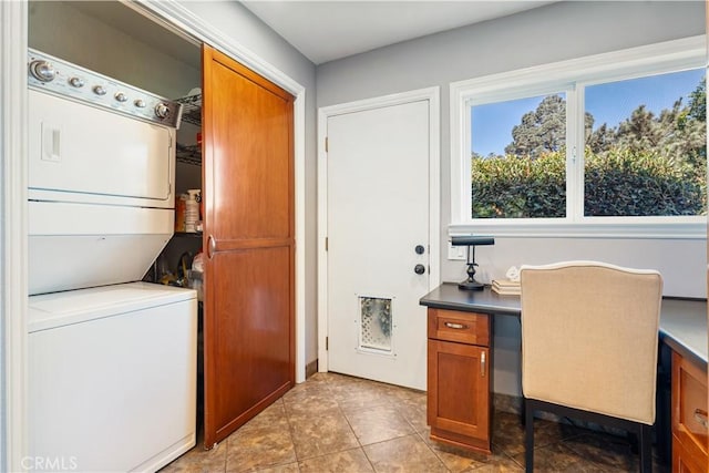 laundry area with stacked washer and clothes dryer and light tile patterned flooring