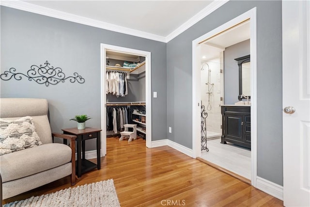 sitting room with ornamental molding and hardwood / wood-style flooring