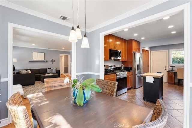 dining space with light tile patterned floors and ornamental molding