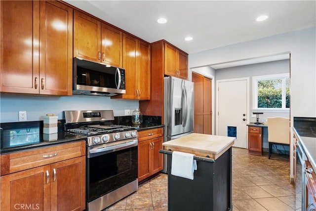 kitchen featuring light tile patterned floors, appliances with stainless steel finishes, and a center island