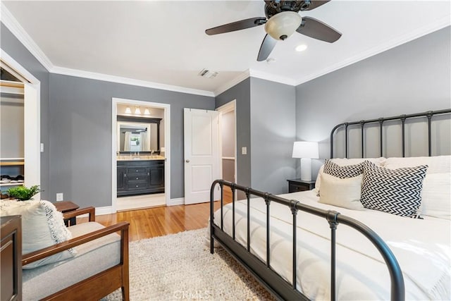 bedroom with ceiling fan, connected bathroom, wood-type flooring, and crown molding