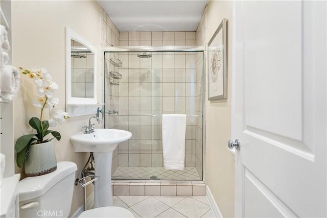 bathroom with toilet, tile patterned floors, and walk in shower