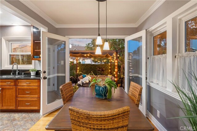 dining space with a wealth of natural light, crown molding, and sink