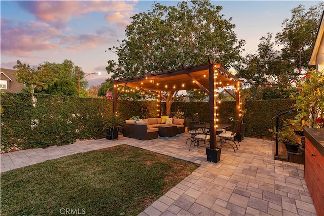 patio terrace at dusk featuring a yard, an outdoor hangout area, and a pergola