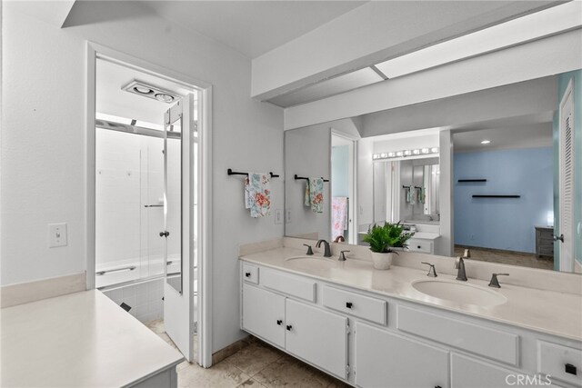 bathroom with vanity and combined bath / shower with glass door