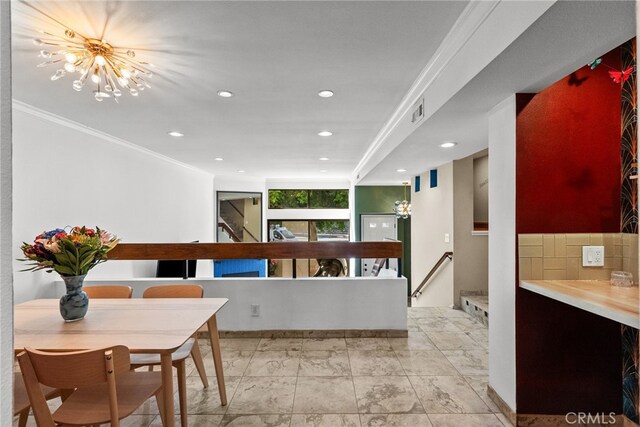 corridor with crown molding and an inviting chandelier