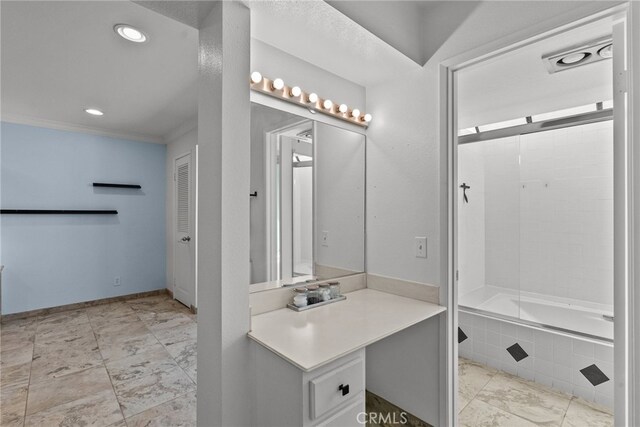 bathroom featuring tiled shower / bath, vanity, and crown molding