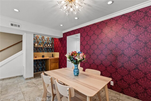 dining room featuring an inviting chandelier, crown molding, and sink