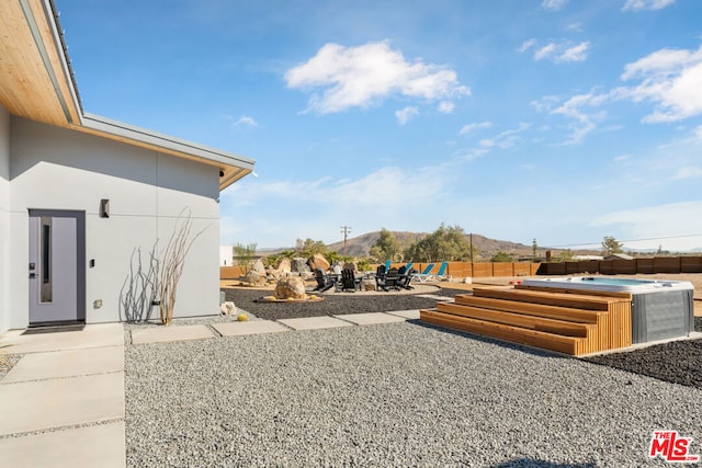 view of yard featuring a patio area, a hot tub, and a mountain view