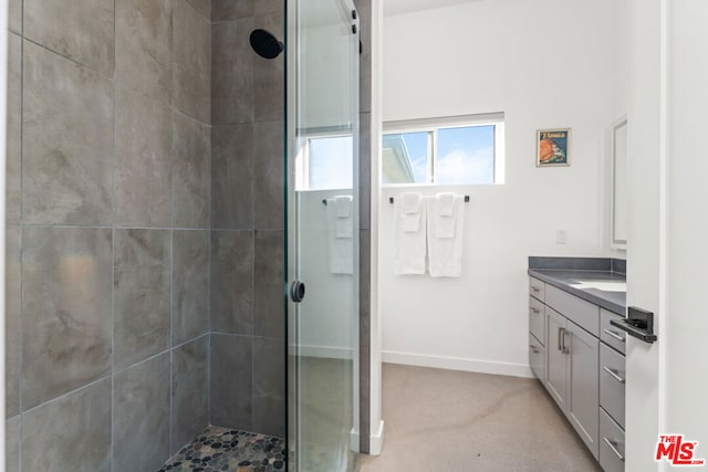 bathroom featuring a tile shower and vanity