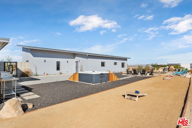 rear view of property with a hot tub