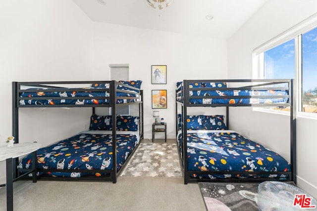 bedroom with carpet floors and vaulted ceiling