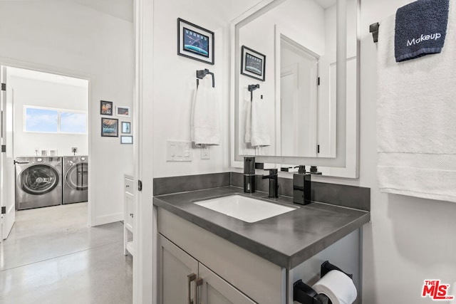 bathroom with washer and clothes dryer, vanity, and concrete floors