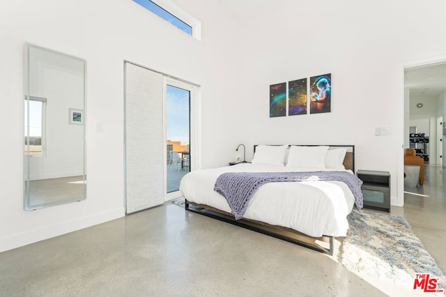 bedroom with multiple windows and concrete flooring