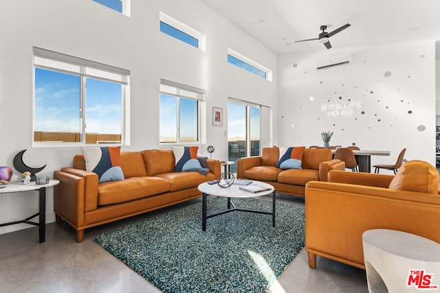 living room with concrete flooring, a towering ceiling, and ceiling fan