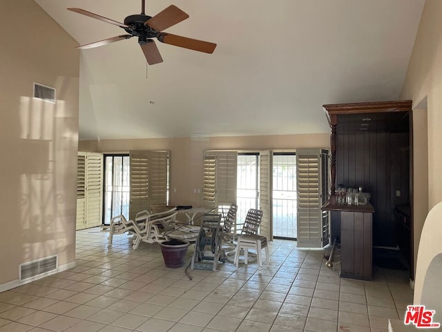 dining area featuring ceiling fan, light tile patterned floors, and high vaulted ceiling